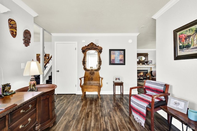 living area with a fireplace, dark wood finished floors, stairway, baseboards, and ornamental molding