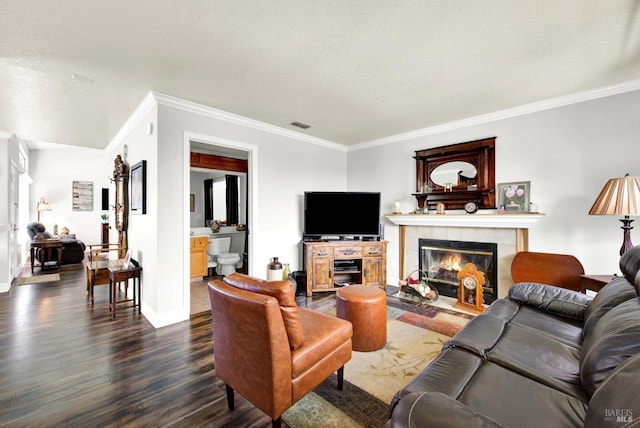 living room featuring baseboards, ornamental molding, visible vents, dark wood-type flooring, and a tile fireplace