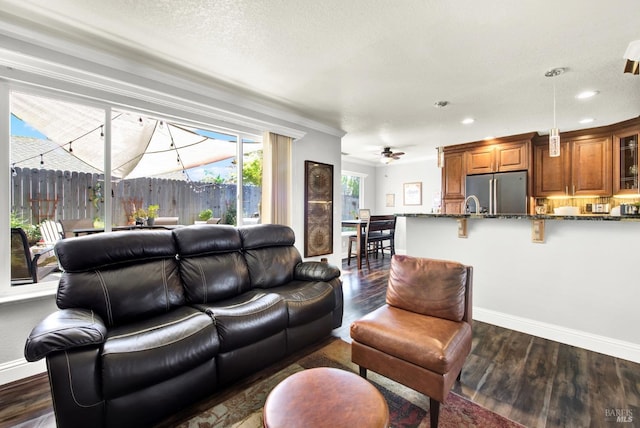 living room featuring dark wood-style flooring, baseboards, a ceiling fan, and recessed lighting