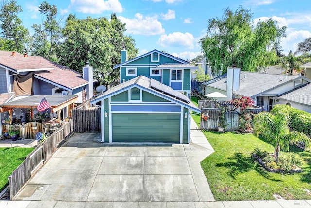 view of front of home with a garage, driveway, fence, and a front yard