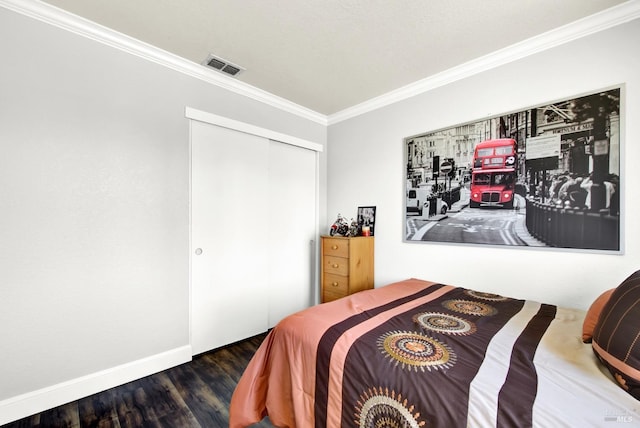 bedroom featuring wood finished floors, a closet, visible vents, baseboards, and ornamental molding