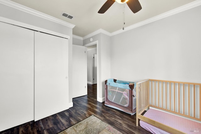 bedroom featuring wood finished floors, visible vents, baseboards, ceiling fan, and ornamental molding