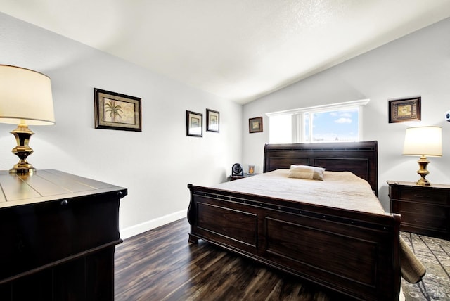 bedroom featuring dark wood-type flooring, baseboards, and lofted ceiling