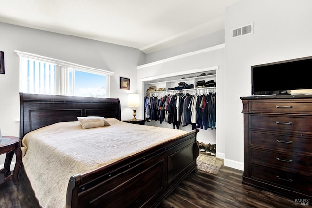 bedroom featuring lofted ceiling, a closet, visible vents, dark wood-style flooring, and baseboards