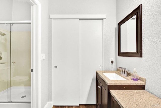 full bath with a stall shower and vanity
