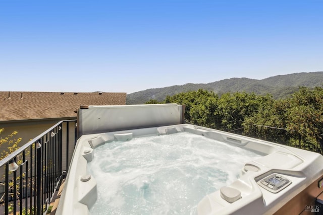 view of patio / terrace featuring a mountain view, a balcony, and a hot tub