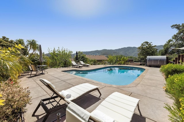 pool featuring a mountain view and a patio area