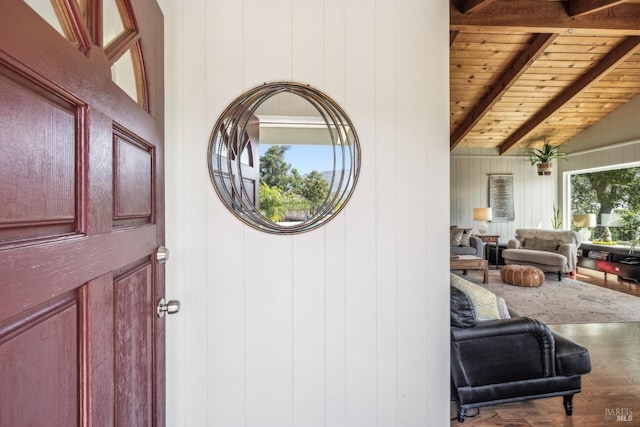 foyer with wooden ceiling, vaulted ceiling with beams, wood finished floors, and wood walls