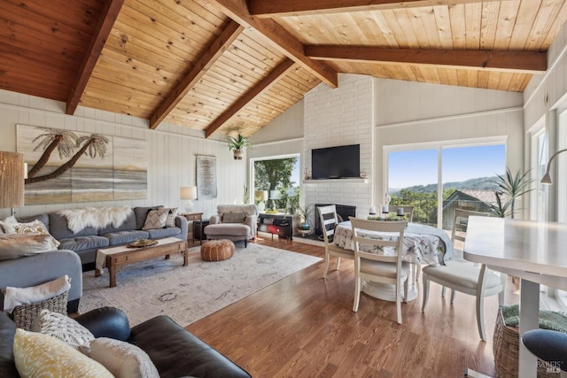 living area featuring a brick fireplace, wooden ceiling, beam ceiling, and wood finished floors