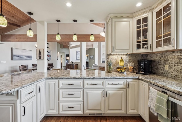 kitchen with tasteful backsplash, open floor plan, glass insert cabinets, and light stone counters