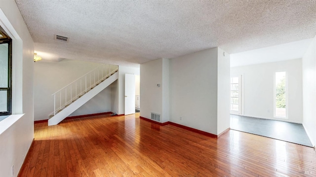 117 Sunset Cir Unit 36, Benicia, CA 94510 - unfurnished living room featuring wood-type flooring, a textured ceiling, stairs, and baseboards