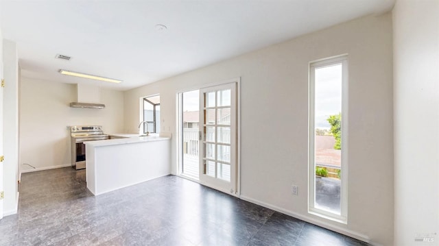 117 Sunset Cir Unit 36, Benicia, CA 94510 - kitchen with electric stove, light countertops, a peninsula, wall chimney exhaust hood, and baseboards