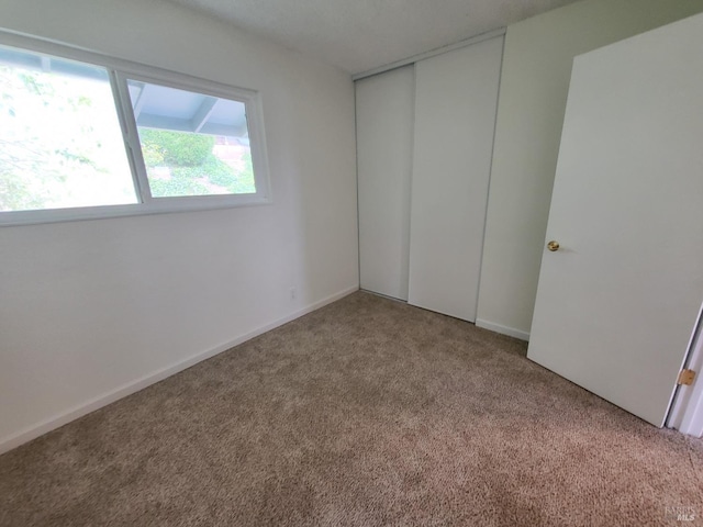 unfurnished bedroom featuring a closet and carpet flooring