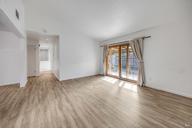unfurnished room featuring light wood finished floors, visible vents, and baseboards