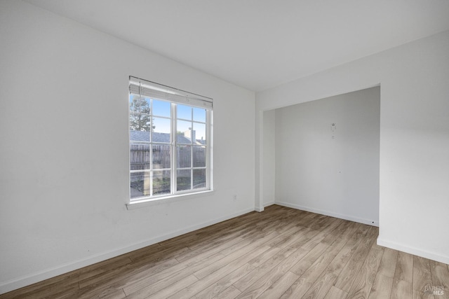 spare room with light wood finished floors and baseboards