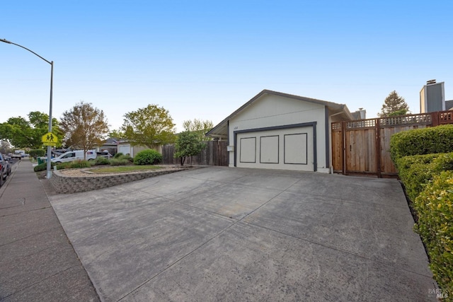 garage featuring driveway and fence