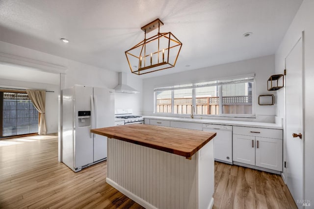 kitchen featuring wooden counters, white appliances, light wood-type flooring, and wall chimney exhaust hood