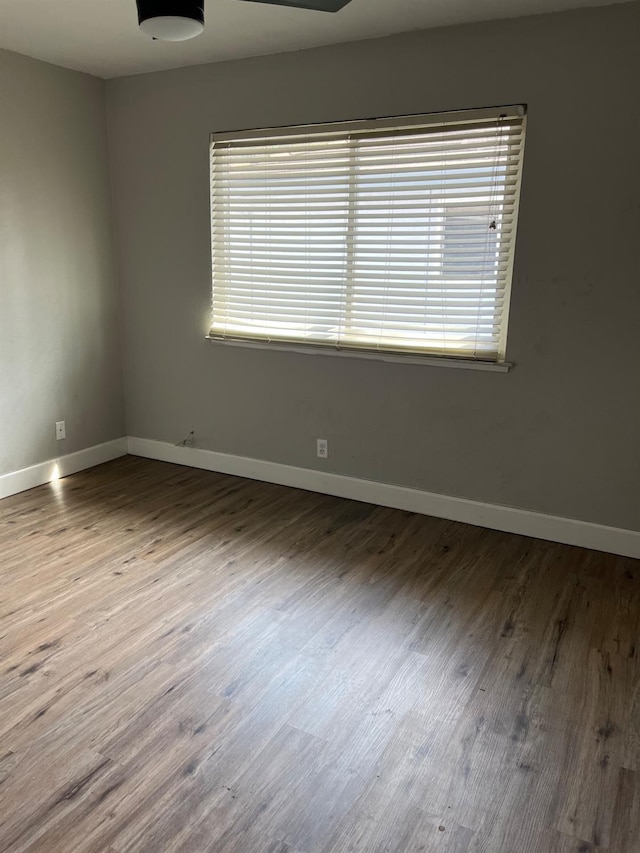 unfurnished room with wood finished floors and baseboards