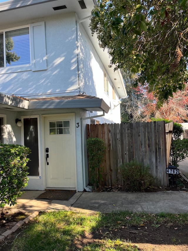 exterior space featuring fence and stucco siding