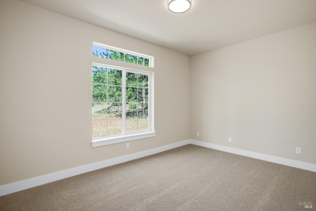 carpeted spare room with baseboards