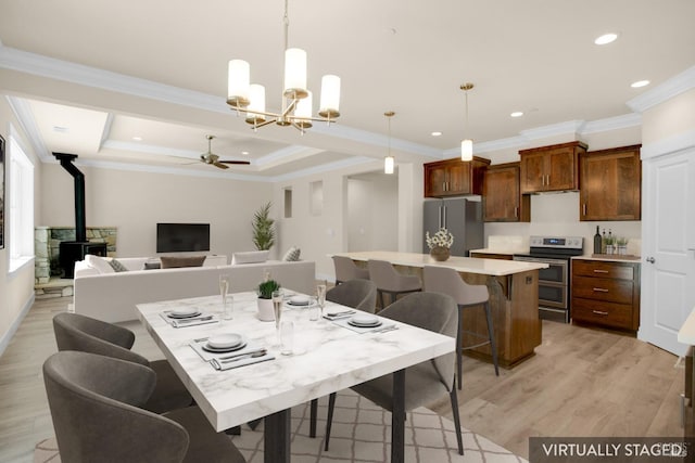 dining room featuring a wood stove, light wood finished floors, recessed lighting, crown molding, and ceiling fan with notable chandelier