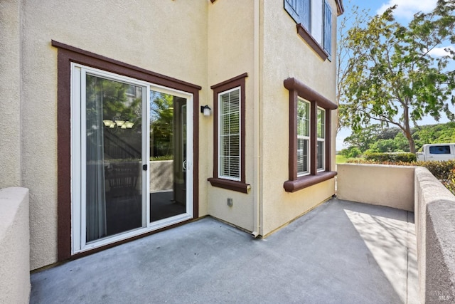 entrance to property featuring stucco siding and a patio area