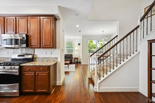 kitchen with baseboards, stainless steel appliances, and dark wood-style floors