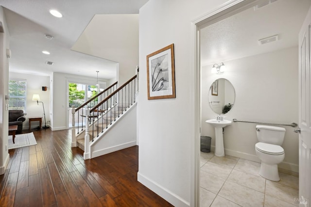 interior space with wood finished floors, visible vents, toilet, and baseboards