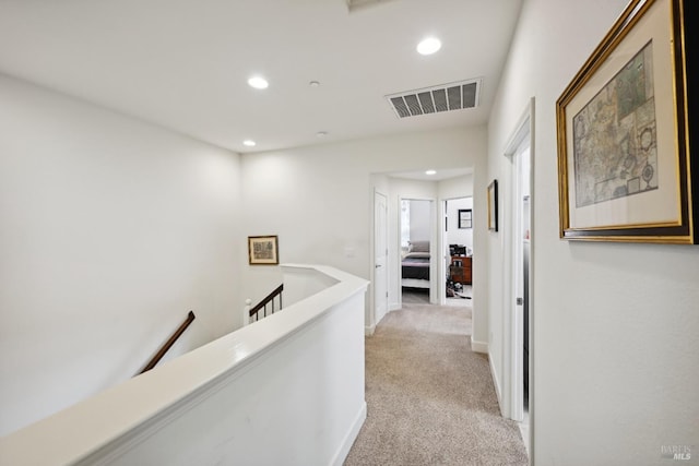 corridor with recessed lighting, an upstairs landing, visible vents, and light carpet