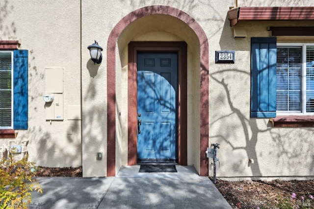 view of exterior entry featuring stucco siding