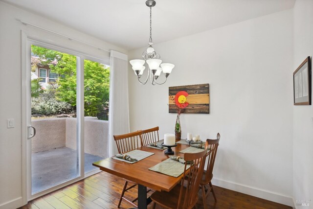 dining room featuring a chandelier, baseboards, and hardwood / wood-style flooring