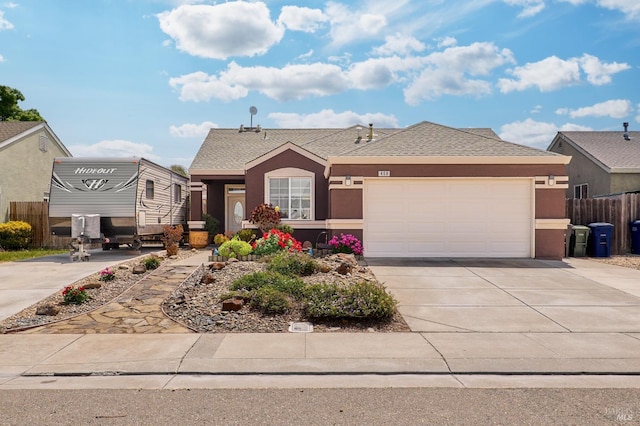 ranch-style house with driveway, fence, roof with shingles, an attached garage, and stucco siding
