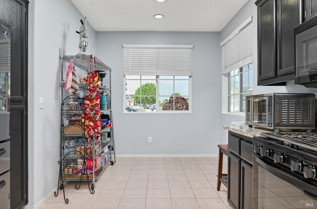 kitchen with dark cabinets, recessed lighting, and baseboards