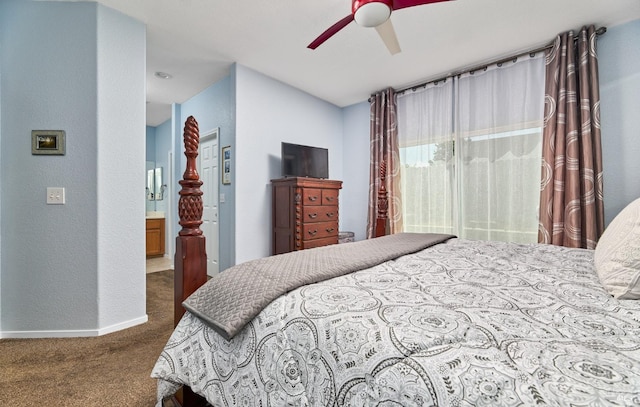 carpeted bedroom with baseboards, ensuite bathroom, a ceiling fan, and a textured wall