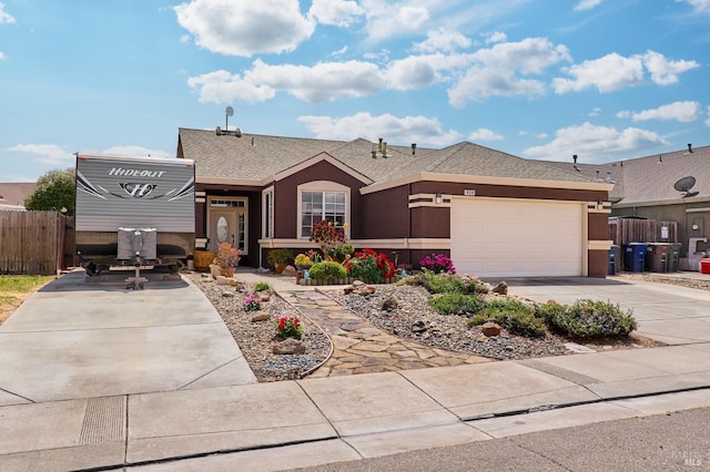 ranch-style home with stucco siding, driveway, roof with shingles, an attached garage, and fence