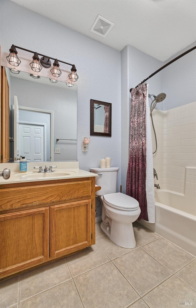 bathroom with tile patterned floors, toilet, a textured wall, vanity, and visible vents