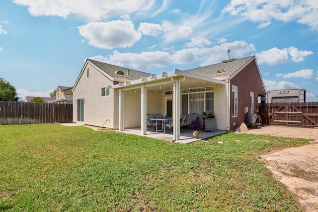 back of property with stucco siding, a patio area, a yard, and a fenced backyard
