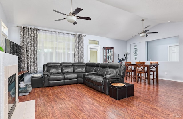 living area with visible vents, wood finished floors, a ceiling fan, and lofted ceiling