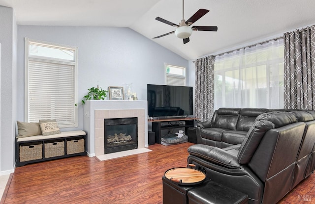living room featuring wood finished floors, ceiling fan, a fireplace, and vaulted ceiling