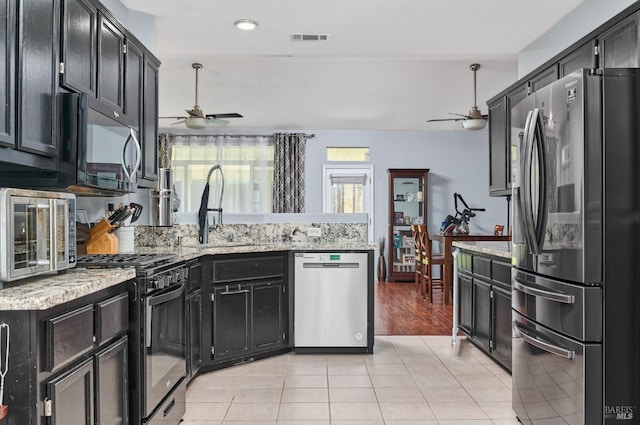 kitchen with visible vents, black appliances, ceiling fan, and a sink