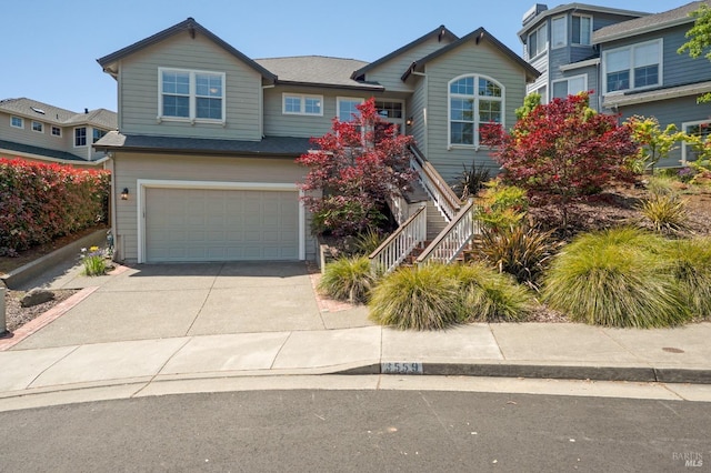 view of front of house featuring an attached garage, driveway, and stairway
