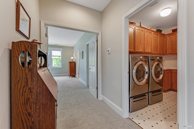 laundry room with visible vents, baseboards, light colored carpet, separate washer and dryer, and cabinet space