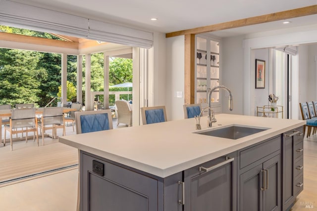 kitchen featuring a sink, light countertops, plenty of natural light, and gray cabinetry