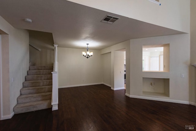 unfurnished dining area featuring visible vents, dark wood-style flooring, a chandelier, and baseboards