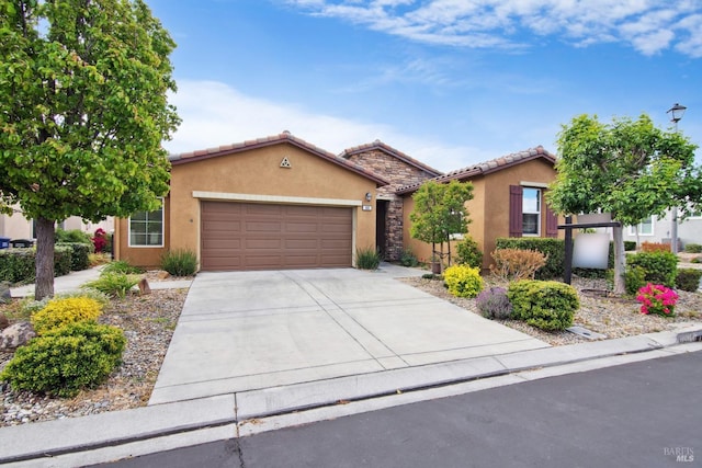 single story home with stucco siding, concrete driveway, a tile roof, and a garage