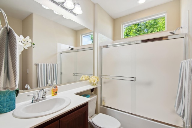 full bathroom with enclosed tub / shower combo, toilet, and vanity