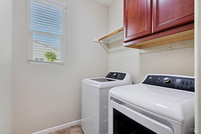 washroom featuring baseboards, separate washer and dryer, and cabinet space