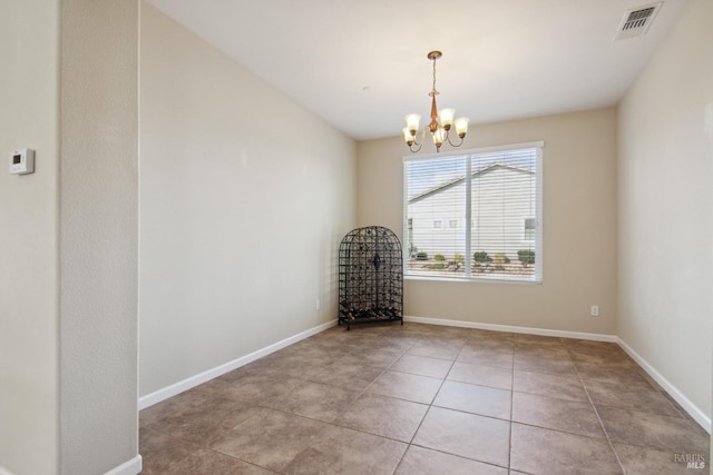 spare room with light tile patterned flooring, visible vents, a notable chandelier, and baseboards