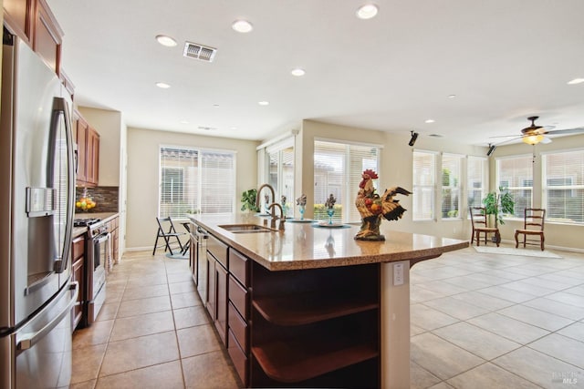 kitchen featuring a sink, stainless steel appliances, light tile patterned floors, open shelves, and tasteful backsplash