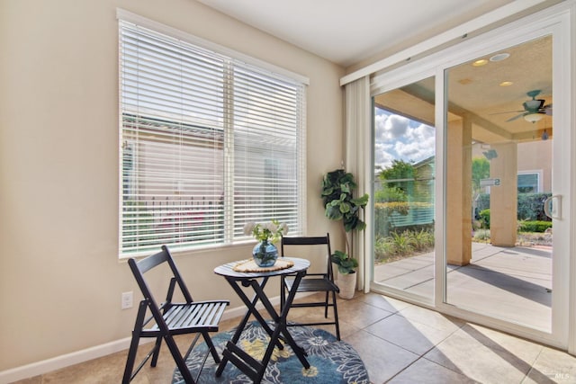 dining area with tile patterned floors, a ceiling fan, and baseboards